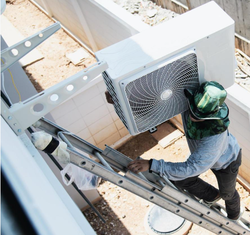 UrbanFix technician mounting outdoor AC unit in Multan