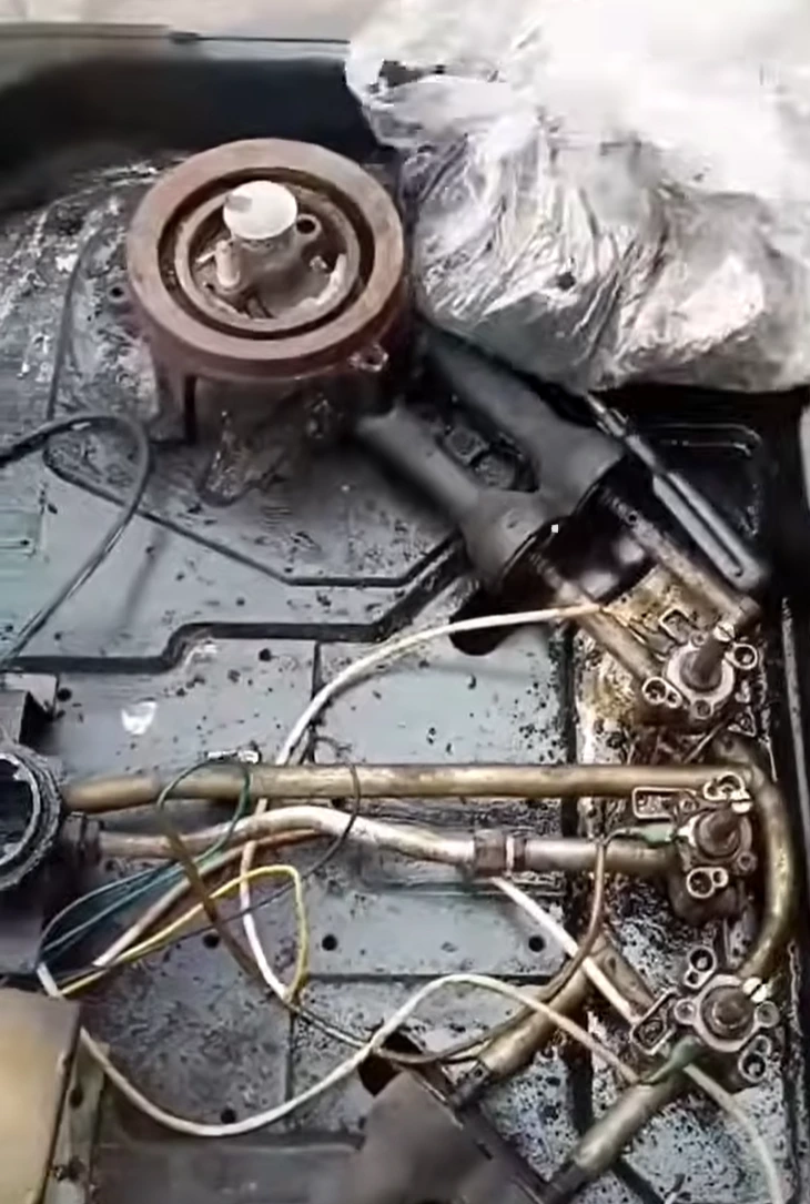 Gas stove opened for repair with burners, gas pipes and valves exposed